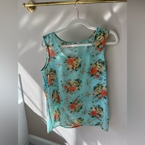 Teal tank top with colorful floral prints and is a size small in women’s